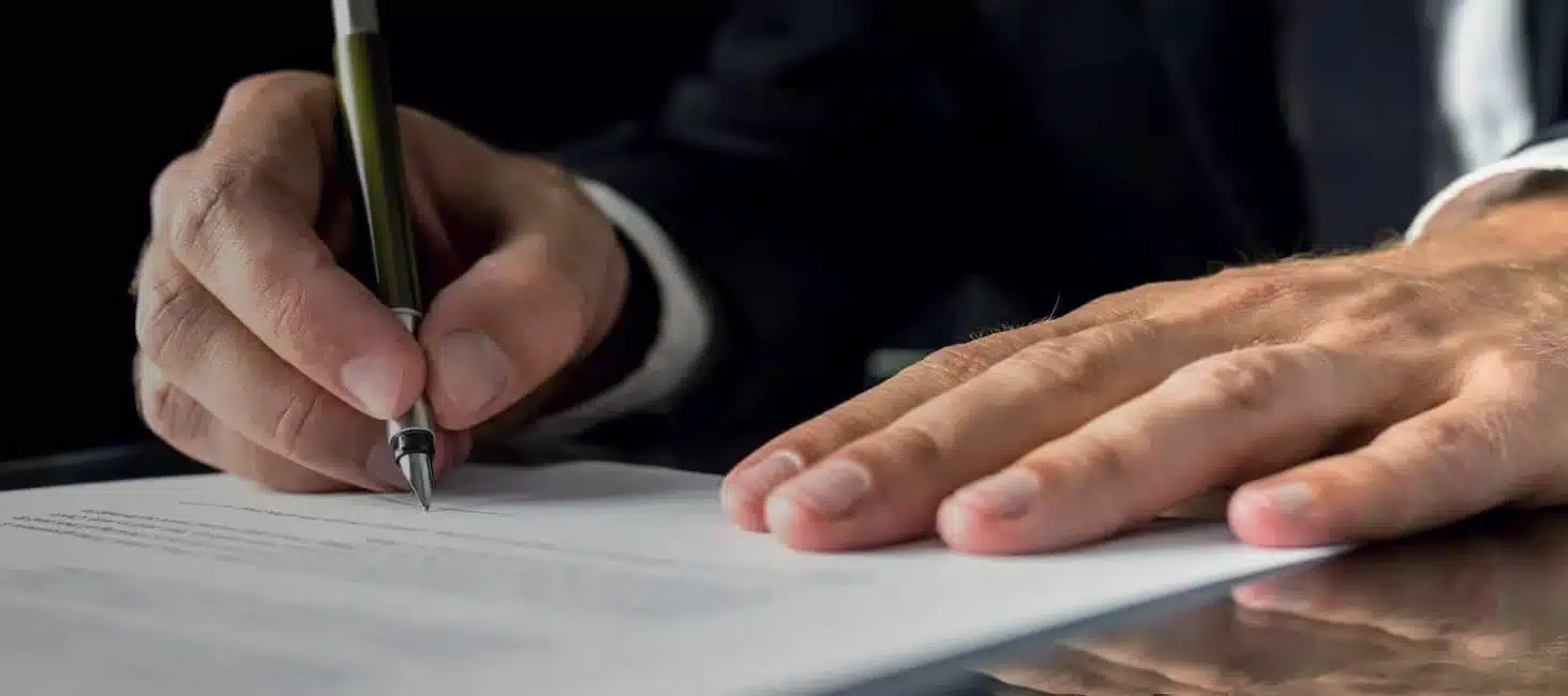  hands of  man in  suit  signing  documents