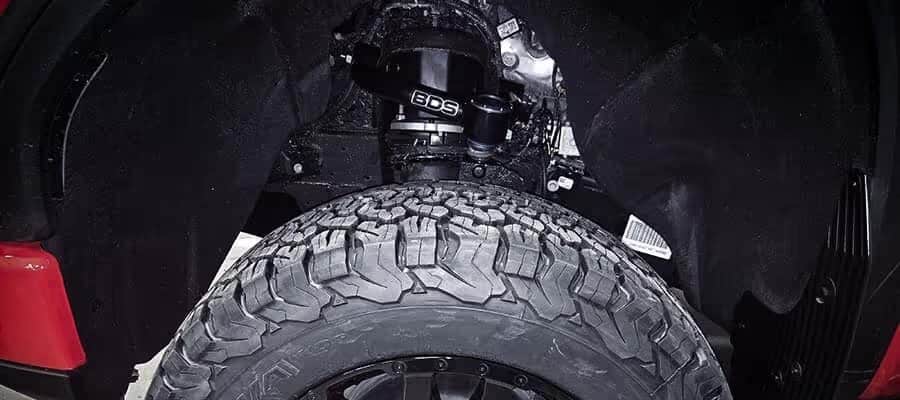 Close-up of an off-road tire under a vehicle with a visible BDS suspension system.