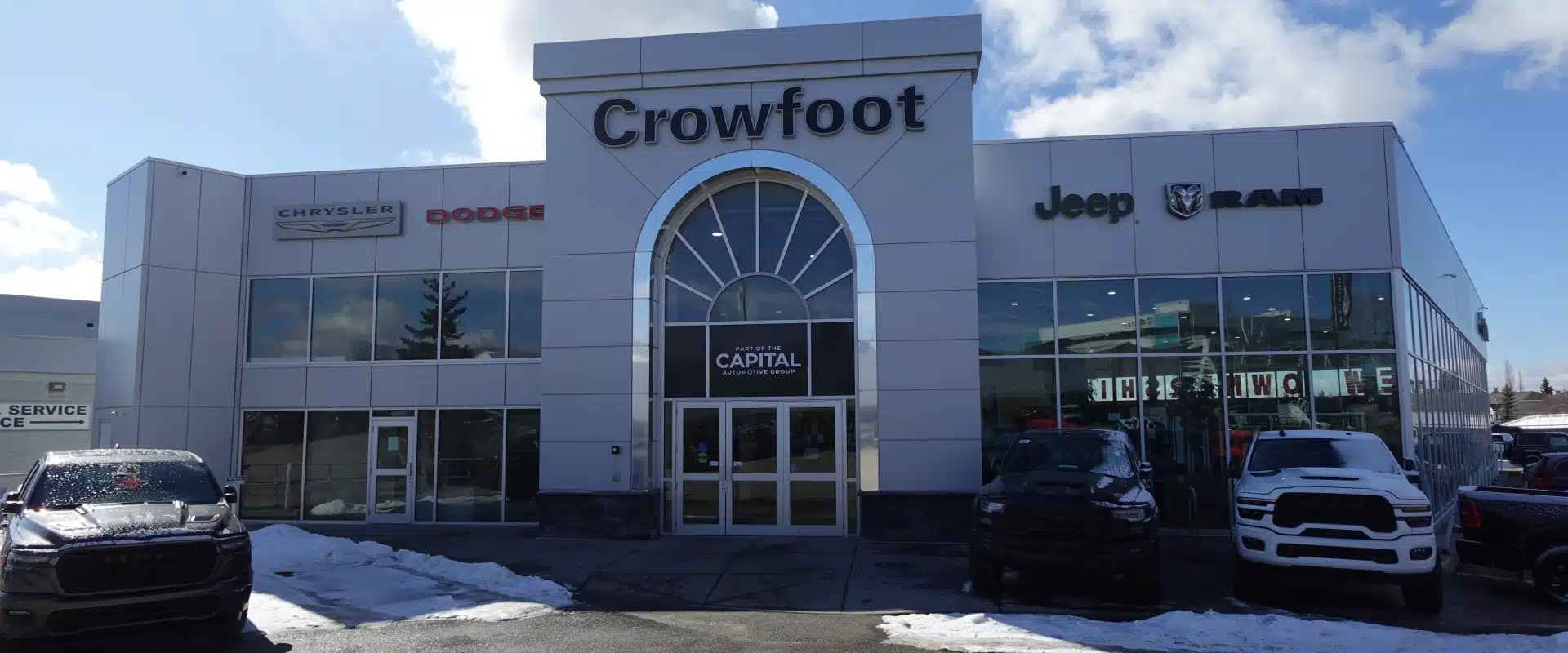 Crowfoot automotive dealership exterior featuring Chrysler, Dodge, Jeep, Ram logos on a sunny day.